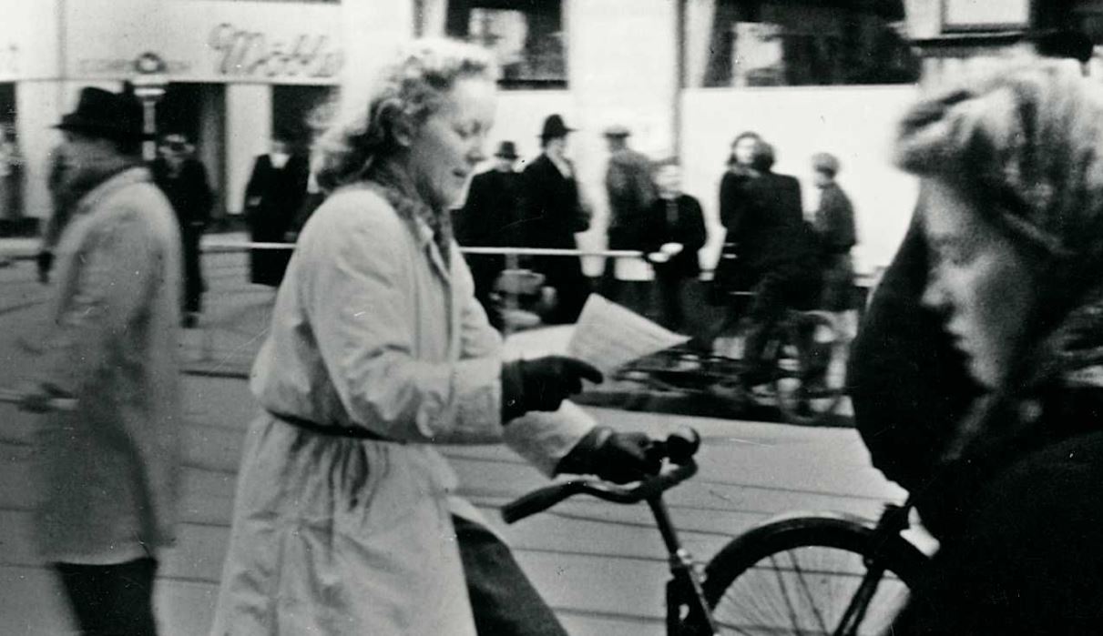 Ung kvinde læser en løbeseddel fra Frit Danmark, hun har fået på gaden. Foto Nationalmuseet/Frihedsmuseet.